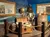 The image displays a pirate-themed exhibit featuring a life-size figure of a pirate with a backdrop of information panels about Blackbeard, framed within a maritime setting with props like a globe, treasure chest, and wooden barrels.
