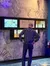 A person stands in front of an interactive display titled 