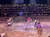 Performers are engaged in an action-packed scene in a sandy arena, while a captivated audience watches from tiered seating in the background.