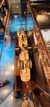 A scale model ship is displayed inside a glass case with reflections creating a striking visual effect.