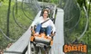 A person is enjoying a ride on the Branson Coaster, an individual cart roller coaster, surrounded by lush greenery.