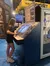 A person is interacting with an exhibit at a museum or educational center, which includes a simulation station and information about side-scan sonar technology.