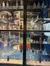 The image shows a display case with various old bottles and a sign stating 