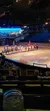 A group of riders on horseback, dressed in historically themed costumes, perform in an arena in front of an audience, likely part of a dinner show or equestrian performance.