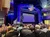 The image shows an elegantly decorated theater with an audience waiting in anticipation for a performance to begin.