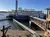 A riverboat is docked at a pier with a walkway leading from the shore to the boat.