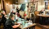A group of people is gathered in a restaurant setting, participating in what seems to be a murder mystery event.
