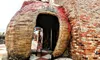 A person stands at the entrance of a building with a giant apple and fork sculpture integrated into its brick exterior.