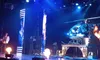 A stage performance featuring a helicopter prop with blue lighting and flames for dramatic effect.