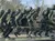 The image depicts a bronze statue of soldiers in combat gear, marching forward with weapons and backpacks.