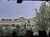 The image shows a view of the Dome of the Rock, a prominent gold-domed structure, surrounded by trees and stone buildings.