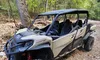 A rugged off-road vehicle is parked on a rocky trail in a forested area.