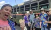 A group of people happily pose in front of a bus labeled