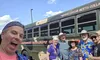 A group of six people happily pose in front of a bus with