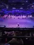 A nighttime arena show features horseback riders holding American flags, with an audience watching from a dining area.
