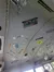 The ceiling of a bus is decorated with various license plates, stickers, and signs.