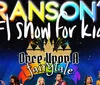 A group of performers on stage dressed in colorful costumes are energetically engaged in a lively act with one holding a sign that reads How to Succeed in Branson Shows
