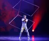 The image shows an acrobat balancing on a unicycle on top of a giant ball with colorful glowing background and quotes praising the New Shanghai Circus
