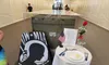 The image shows a memorial display featuring a POW-MIA flag, an explanatory sign, and a small table with symbolic items, including a single rose and an American flag.