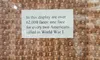 The image shows a display with over 62,000 faces of soldiers, each representing two Americans killed in World War I, accompanied by an explanatory note.
