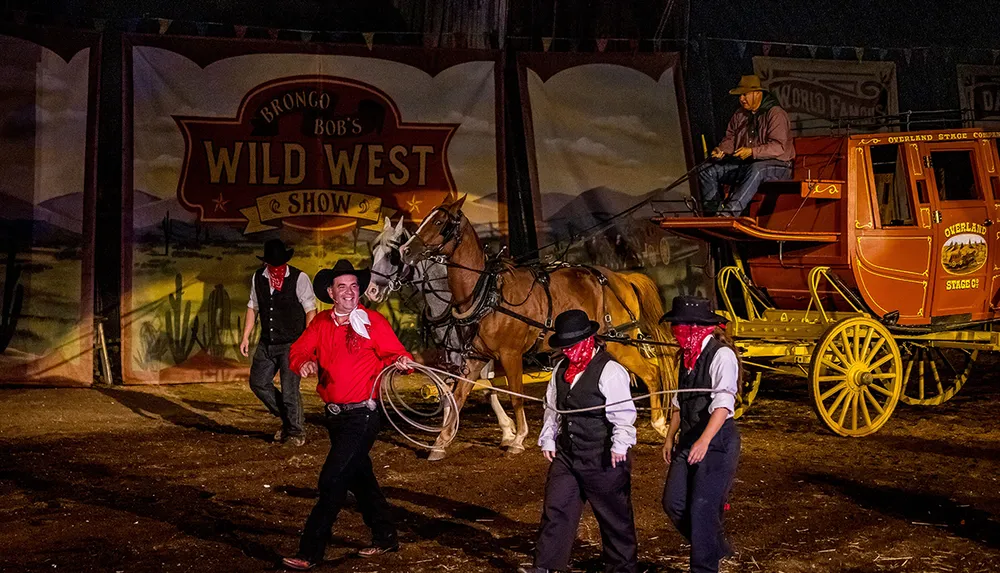 Performers in Wild West attire are present in front of a stagecoach with one man smiling and twirling a lasso evoking the atmosphere of a classic western show