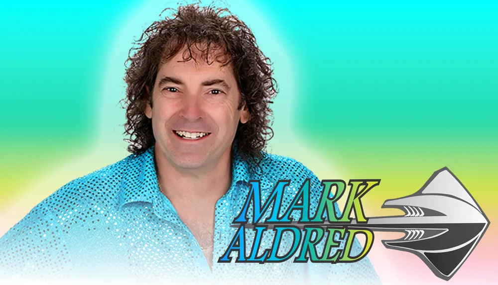 A smiling man in a sparkly blue shirt is set against a colorful gradient background with the name Mark Aldred and a stylized arrow logo