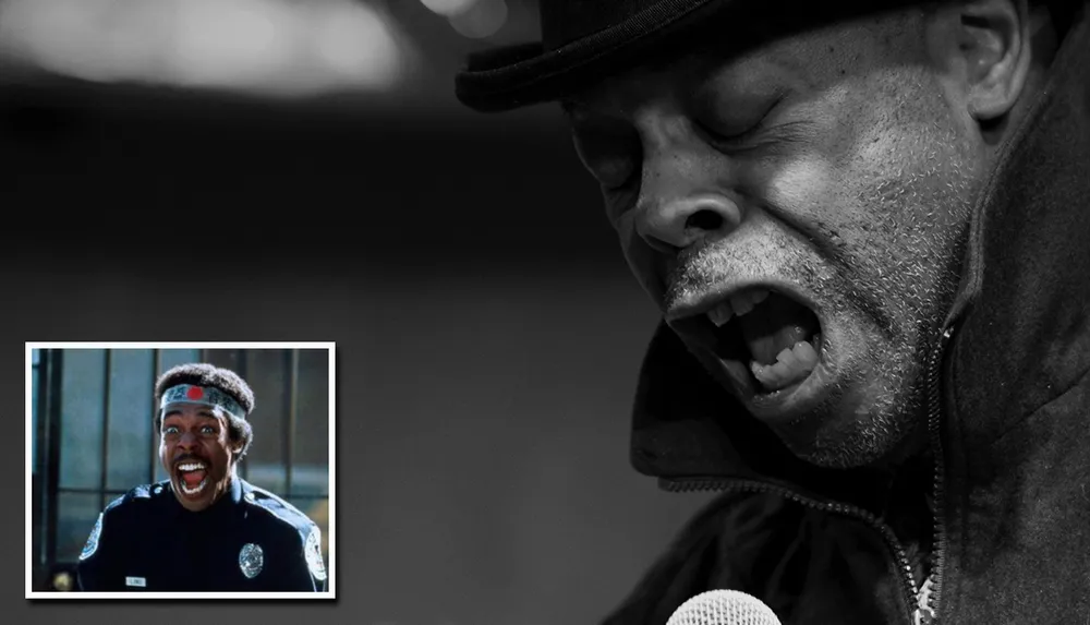 The image features a black-and-white close-up of a man passionately singing into a microphone with an inset color photo of a man in a police uniform excitedly shouting